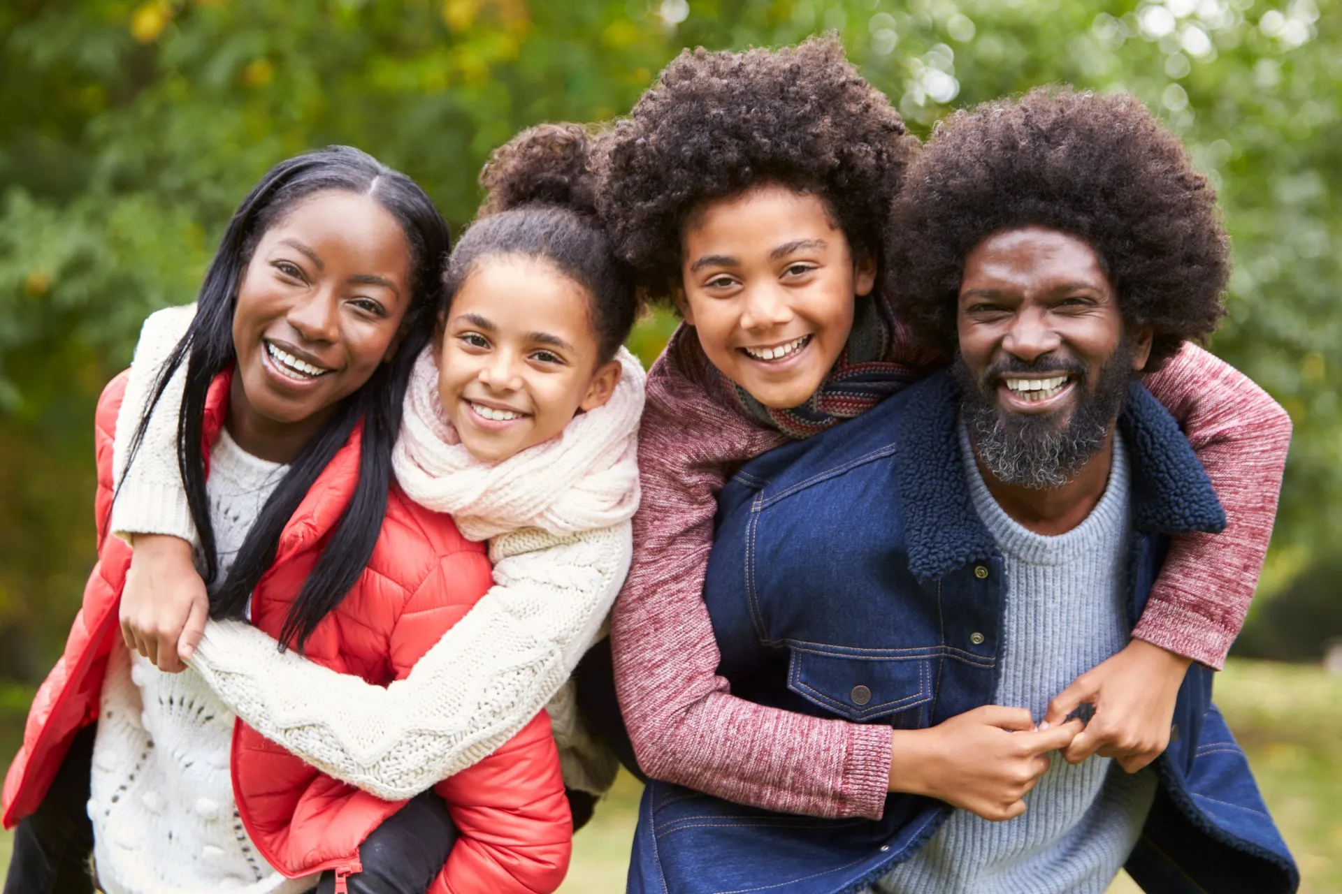 Foster parents being hugged from behind by foster children