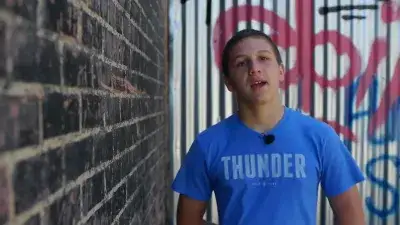 foster child standing next to a brick wall