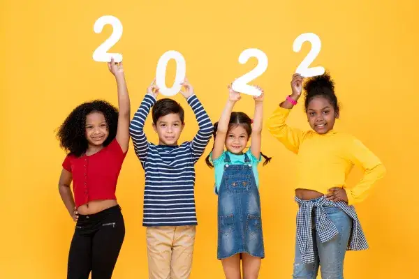 four Kids holding up 2022 in numbers on a yellow background