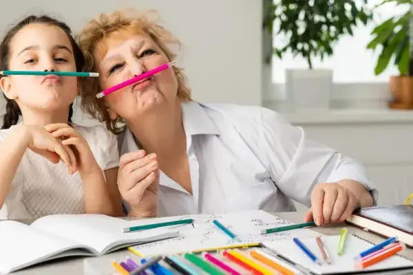 Foster mom and school-aged child having play fun with art supplies.