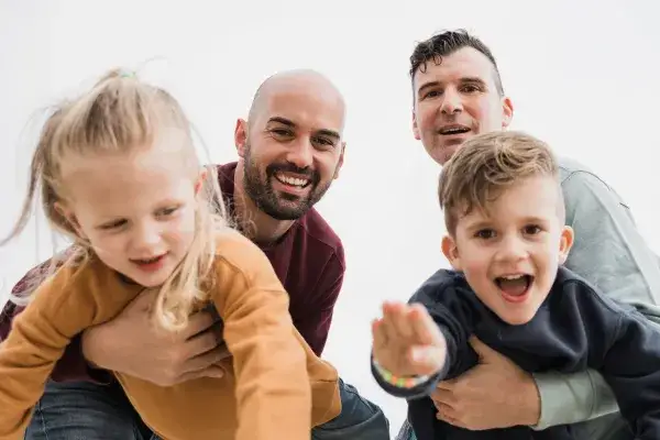 Two fathers and Two foster children horsing around in laughter