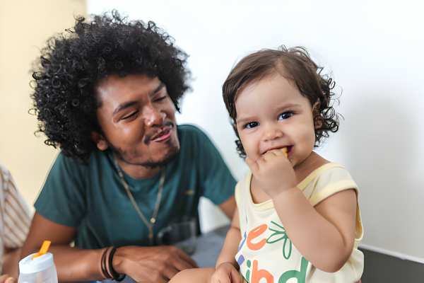 Young father and his daughter having breakfast together in apartment living room