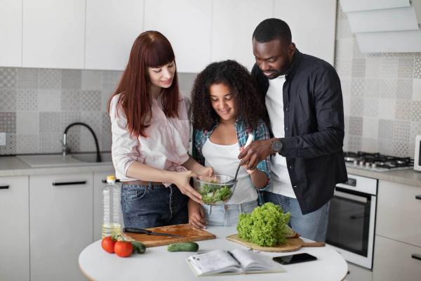 Foster Family of three setting a dinner table